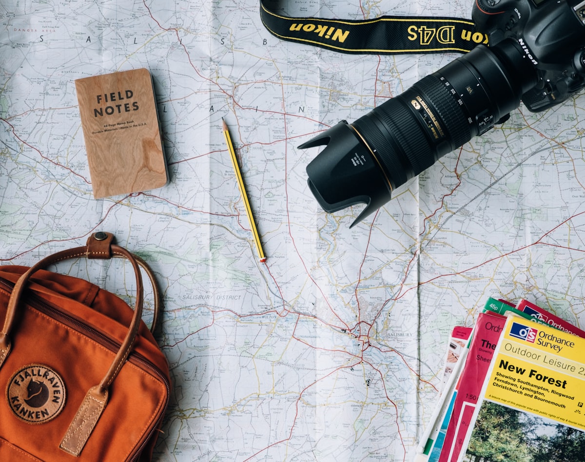 Essentiels de voyage posés sur une carte du monde